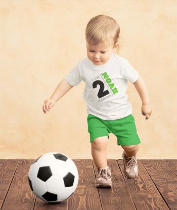 Toddler wearing personalised t shirt, kicking football
